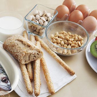 intolleranze alimentari Assorted food items including breadsticks, eggs, milk, and nuts on a countertop.